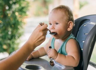 Beba sedi u hranilici dok je majka hrani