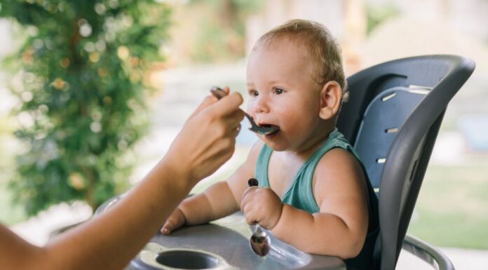 Beba sedi u hranilici dok je majka hrani