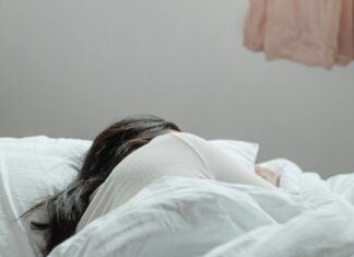 Kako prostor utiče na kvalitet sna i regeneraciju mišića? Devojka spava u krevetu ispod prozora