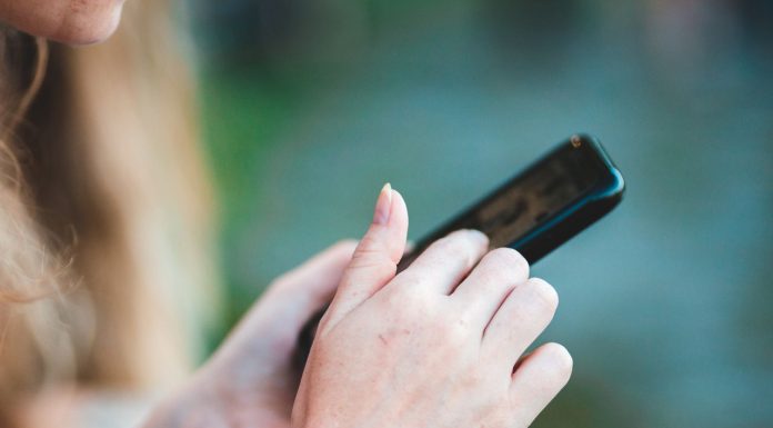 Savremeni trendovi online zabave: Zašto sve više korisnika bira 1xBet Devojka drži mobilni telefon u ruci