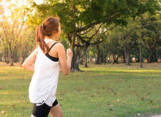 Devojka u sportskoj opremi trči u parku