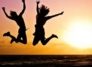 Kako prirodno podstaći dopamin kroz ishranu i navike Dvoje ljudi skaču, zalazak sunca u pozadini