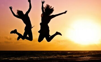 Kako prirodno podstaći dopamin kroz ishranu i navike Dvoje ljudi skaču, zalazak sunca u pozadini