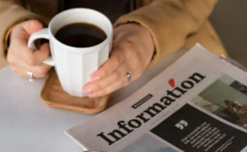 Da li je moguće biti zdrav i hedonista? Odgovor možda iznenađuje Osoba sedi za stolom na kojem se nalaze novine dok drži šolju kafe.