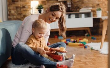 Koje vežbe možete raditi sa bebom? mama sedi na podu sa sinom u naručju