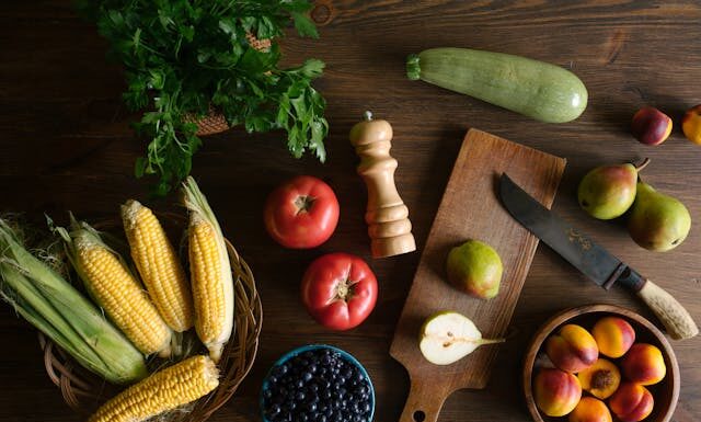 Raznovrsno povrće na dasci i drvenom stolu.