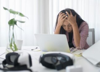 Kako očuvati produktivnost i mentalnu stabilnost uprkos stresu? Žena se drži za glavu na svom radnom mestu.