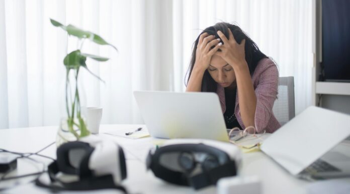 Kako očuvati produktivnost i mentalnu stabilnost uprkos stresu? Žena se drži za glavu na svom radnom mestu.
