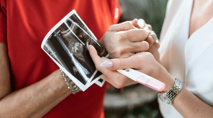 Kako partner može biti podrška tokom trudnoće Muškarac drži za ruku ženu koja drži sliku ultrazvuka i test na trudnoću