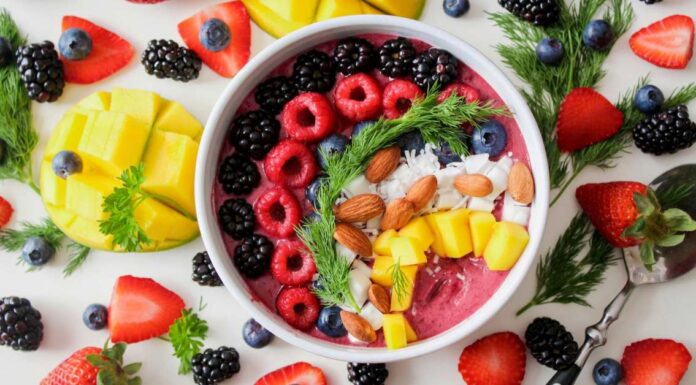 Superhrana na dohvat ruke. Jedite bolje, osećajte se bolje Zdrava voćna kaša u beloj činiji oko nje iseckano voće.